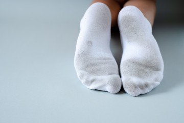 Pair of child feet in dirty stained white socks. dirty socks Pair of child feet in dirty stained white socks. Kid soiled socks while playing outdoors. Children clothes bleaching and.