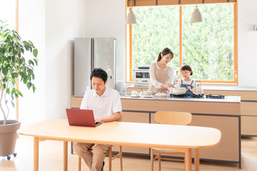 家でテレワークする男性と家族