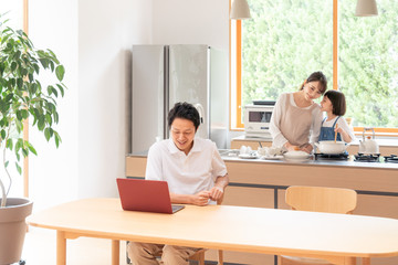 家でテレワークする男性と家族
