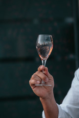 Glass of white sparkling wine at a summer tasting in the hand of a model.