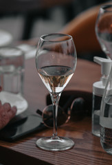 Glass of white sparkling wine at a summer tasting in the hand of a model.