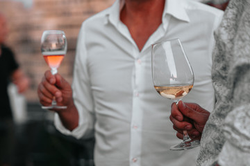 Glass of white sparkling wine at a summer tasting in the hand of a model.