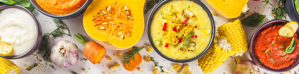 Different autumn soups set. Assortment vegetable soups in portion bowls - corn, potato, pumpkin, tomato, zucchini, broccoli cream soups. top view copy space