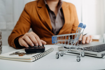 Businesswomen hands working with finances about cost and calculator and laptop with tablet, smartphone at office in morning light