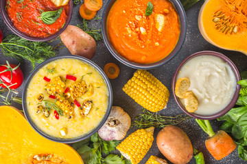 Different autumn soups set. Assortment vegetable soups in portion bowls - corn, potato, pumpkin, tomato, zucchini, broccoli cream soups. top view copy space