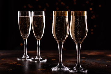 selective focus of glasses full of champagne against christmas lights