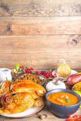 Happy Thanksgiving concept. Thanksgiving day celebration dinner setting with traditional meal and food - green beans, mashed potatoes, cranberry sauce, pumpkin soup, autumn fruits, vegetables