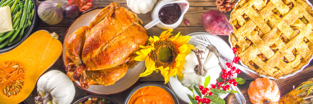 Happy Thanksgiving concept. Thanksgiving day celebration dinner setting with traditional meal and food - green beans, mashed potatoes, cranberry sauce, pumpkin soup, autumn fruits, vegetables