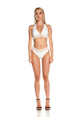 Woman in white bikini posing in studio on white background.