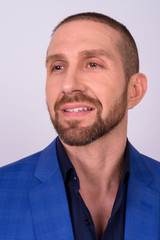 Obraz premium Portrait of happy handsome bald bearded businessman in suit