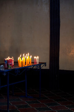Candles and offerings at altar in Maximon San Simon temple near Antigua Guatemala