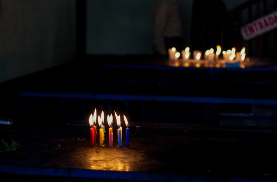 Candles of different color on the table in Maximon San Simon temple near Antigua Guatemala