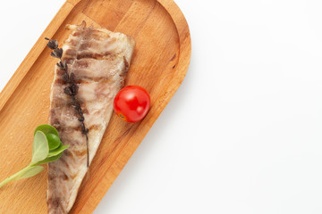 Fish fried on the grill and served on a plate with fresh vegetables