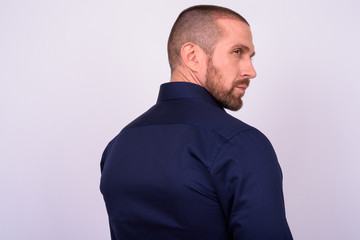 Rear view of handsome bald bearded businessman looking over shoulder