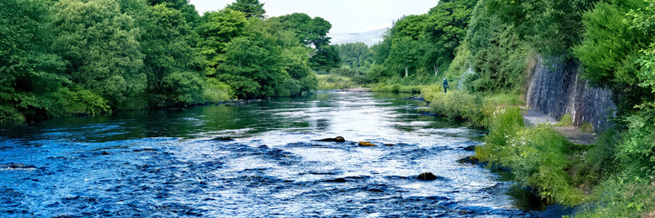 Fototapeta premium Man salmon fishing in the Rock Pool on the River Brora in Sutherland in the Highlands of Scotland