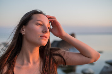 Dreamy female touching hair near sea