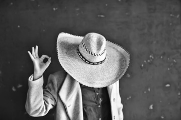 man in a straw hat with brim in the studio gestures with his hands and fingers, points. West...