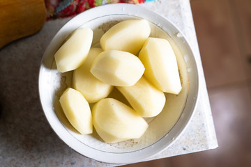 Peeled potatoes are in a plate