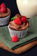 Cupcake de chocolate con frutos rojos sobre tabla de madera