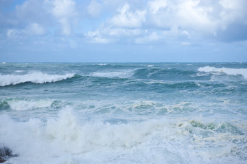 Naklejka na ściany i meble Foamy stong waves crashing in the ocean
