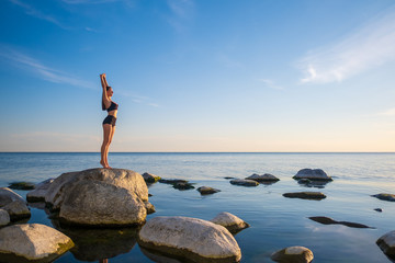Woman standing on seashore in Mountain pose