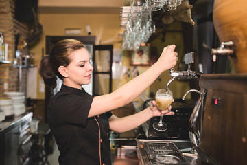 Waitress tapping faucet beer in bar