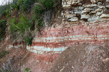 textures of various clay layers underground in  clay quarry after  geological study of  soil. colored layers of clay and stone in  section of  earth, different rock formations and soil layers.