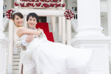 新婦をお姫様抱っこをする新郎