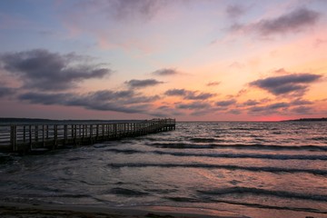 Steg am Ostsee Strand mit Wellen in der Morgen Dämmerung