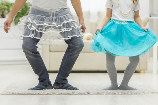 Photo of crop legs of father and daughter wearing funny clothes. - Powered by Adobe