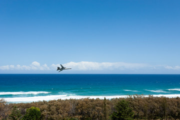 Fighter jet flying over the Australian beach