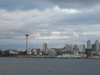 Fototapeta premium Space Needle and part of Seattle skyline seen from the sea on a cloudy evening. 