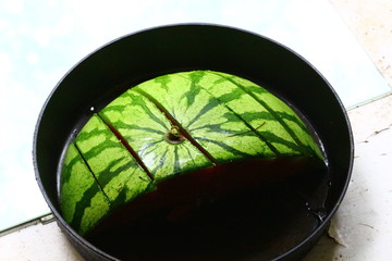 Fototapeta na wymiar Sliced water melon in a cast iron skillet