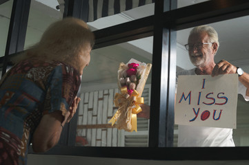 Senior couples expess love as they are seperated during coronavirus covid 19 quarantine as a new...