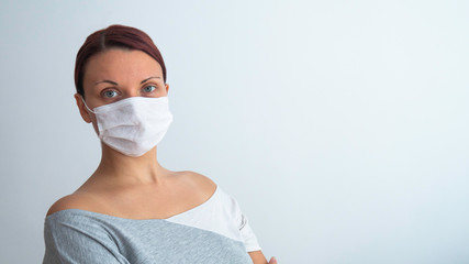 Caucasian woman with white medical mask on her face. Negative space or copy space for text.