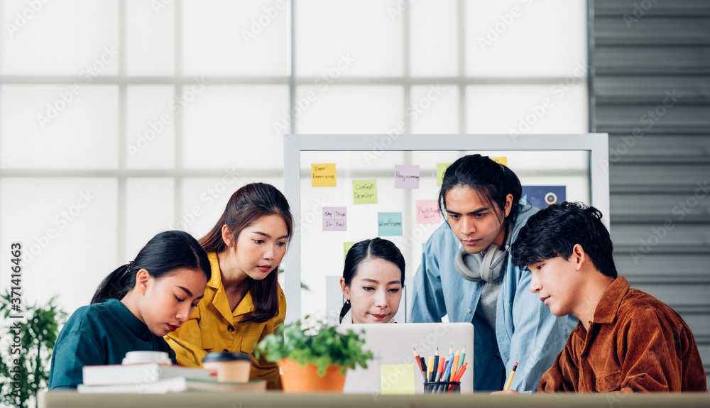Poster group of asian ux developer and ui designer serious brainstorming about mobile app interface on meeting table at modern office.Creative digital development agency
