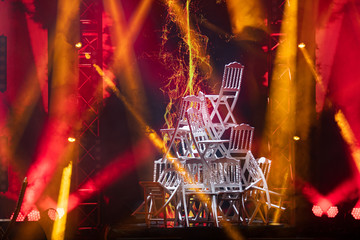Pyramid of white chairs on stage