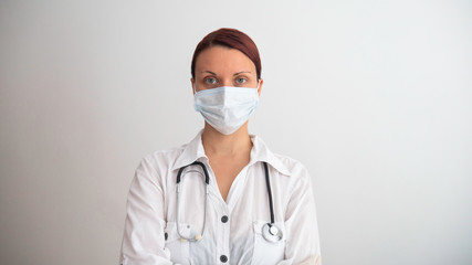 Covid19, coronavirus, healthcare and doctors concept. Portrait of professional confident young doctor in medical mask and white coat, stethoscope over neck.