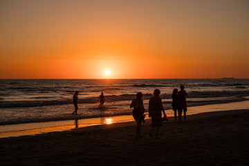 Fototapeta premium Silhouettes of people taking photos at sunset on the beaches of Cadiz, Spain