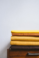 Fall autumn Minimalism, simple, Neutral color negative space background mockup with copy space. Fall autumn color palettes compositions with stack of yellow brown fabrics