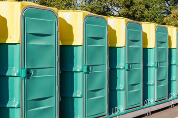 A row of green mobile toilet cabin