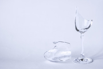 Broken glass and shards on light gray background, selective focus