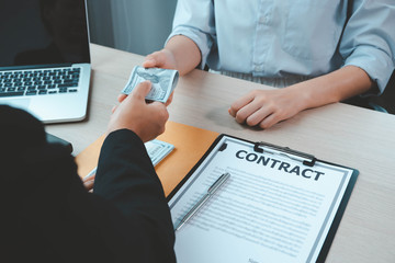Bribery and corruption concept, bribe in the form of dollar bills, Businessman giving money while...