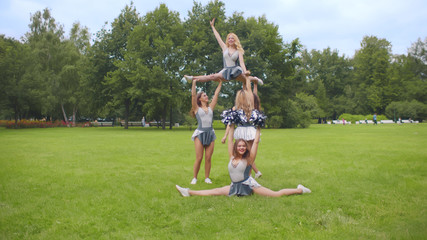 Cheerleaders practicing athletic elements preparing for performance