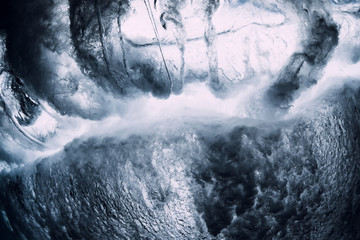 Crashing wave with foam and air bubbles underwater. Transparent sea water
