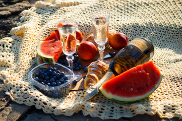 vacation picnic two glasses of champagne, blueberries, watermelon and croissants