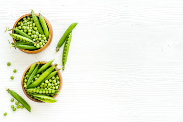 Bowl of green pea pod with beans on kitchen desk. Top view