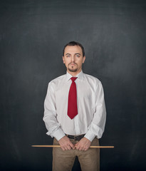 Serious business man or teacher with pointer on blackboard