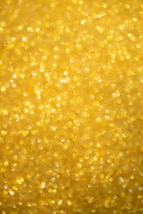 Gold glitter sparkles with bokeh effect. Festive background with bright golden lights. Christmas mood concept. Copy space texture, flat lay. Defocus blur.