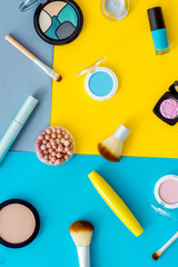 Lauout of multicolor cosmetics - powder concealer eye shadow lipstic. Top view